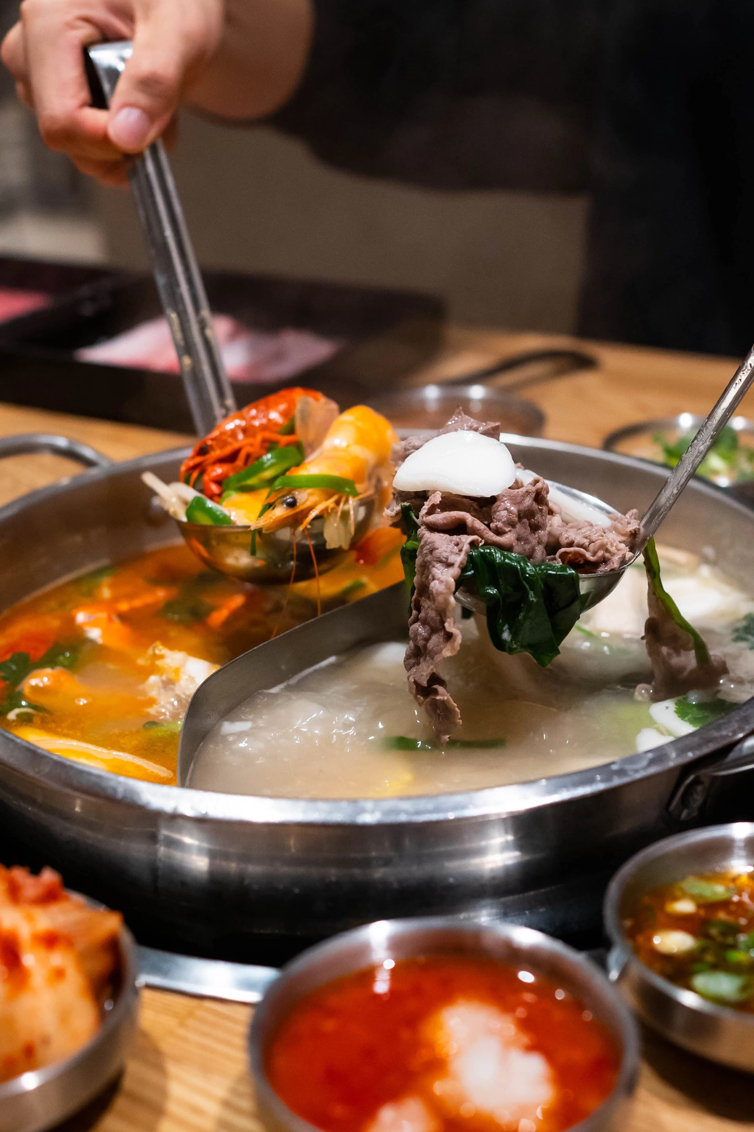 Cooking beef in shabu-shabu broth at table